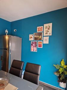 una cucina con parete blu, 2 sedie e un frigorifero di The Clover a San Pawl il-Baħar