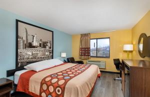 um quarto de hotel com uma cama e uma televisão em Super 8 by Wyndham Eddyville/Kuttawa em Eddyville