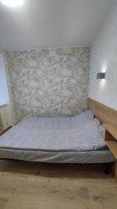 a bed in a room with a stone wall at Євроапартаменти з парковкою in Rivne