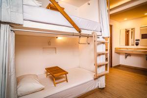 a room with two bunk beds and a table at Nomads Party Hostel in Cancún