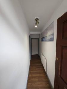 a hallway with a ceiling fan and a hallway with a hallway at Kensington Stories - 4 Bed House in Watford