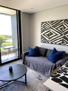 a living room with a couch and a table at Upmarket Modern 1 Bedroom Apartment in Durban
