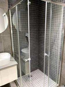 a shower with a glass door in a bathroom at Upmarket Modern 1 Bedroom Apartment in Durban
