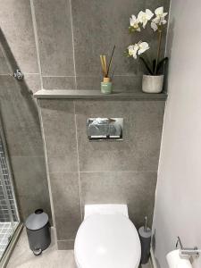 a bathroom with a toilet and flowers on a wall at Upmarket Modern 1 Bedroom Apartment in Durban