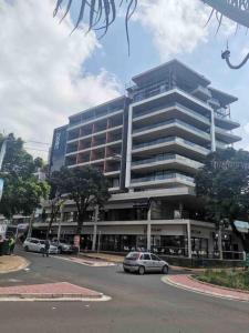 a large building with cars parked in front of it at Upmarket Modern 1 Bedroom Apartment in Durban