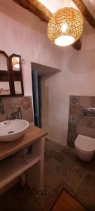 a bathroom with a sink and a toilet and a chandelier at Casa Fabian in Polopos