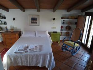 - une chambre avec un lit blanc et une chaise dans l'établissement Villa Carmen Magnificent Country House in Serranía, à Ronda