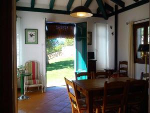 une salle à manger avec une table et une porte donnant sur une cour dans l'établissement Villa Carmen Magnificent Country House in Serranía, à Ronda