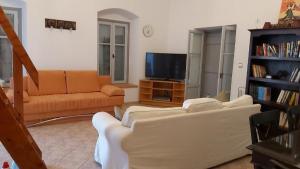 uma sala de estar com dois sofás e uma televisão em KAS RESIDENCE renovated 2022 em Spetses