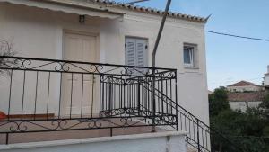 einen Balkon mit einem schwarzen Geländer an einem Haus in der Unterkunft KAS RESIDENCE renovated 2022 in Spetses