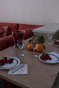 a table with plates of strawberries and wine glasses at Stavros Niarhos apartment in Athens