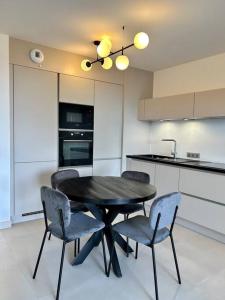uma mesa preta e cadeiras numa cozinha em Le Lily - T2 neuf vue mer em Èze