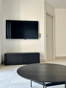 um quarto com uma mesa e uma televisão na parede em Le Lily - T2 neuf vue mer em Èze