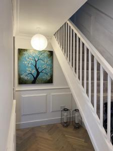 a hallway with a staircase with a painting on the wall at Greens Walk in Liverpool