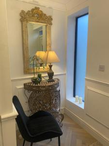 een tafel met een lamp en een stoel in een kamer bij Greens Walk in Liverpool