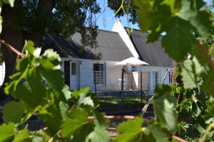 a white building with an umbrella in front of it at De Kombuys in Oudtshoorn