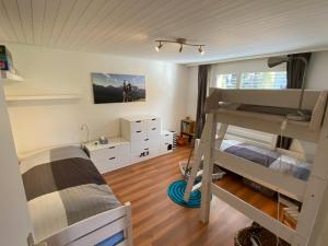 - une chambre avec deux lits superposés et une chambre avec un lit dans l'établissement Apartment Arvenbüel-Flüügespitz, à Amden