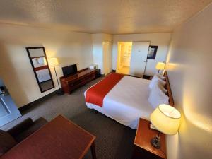 a hotel room with a bed and a desk at Budget Motel in Burley