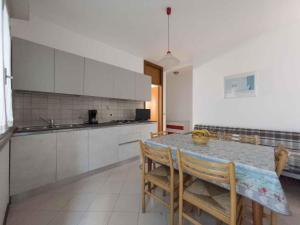 kuchnia ze stołem, krzesłami i blatem w obiekcie Apartments in Lignano 21774 w Lignano Sabbiadoro
