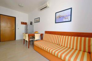 - un salon avec un canapé et une table dans l'établissement Apartments in Lignano 21633, à Lignano Sabbiadoro