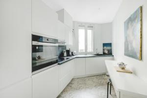 una cucina bianca con armadi bianchi e una finestra di 2 bedrooms center of Clichy ! a Clichy