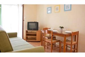 a living room with a table and a tv at Apartments Mirko in Seget Vranjica