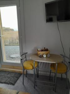 stół i 2 krzesła ze stołem i oknem w obiekcie Lealt Falls Apartment w mieście Culnacnoc