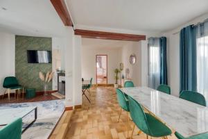 een woonkamer met een grote tafel en groene stoelen bij Belle maison Paris/Disney in Sucy-en-Brie