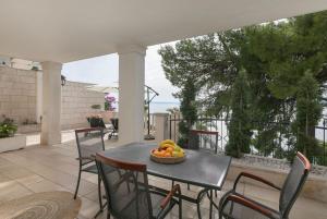 a table with a bowl of fruit on a patio at Apartments Kate in Brela