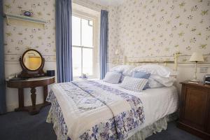 um quarto com uma cama com um espelho e uma janela em The Old Rectory em Coniston