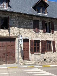 ユセルにあるChambre calme au cœur d’Usselの茶色のドアと窓のある古い石造りの建物