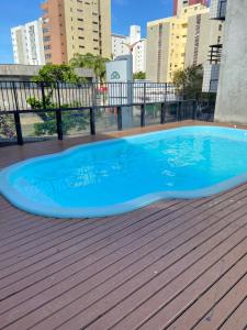 une grande piscine bleue sur une terrasse en bois dans l'établissement Flat com vista para o Mar, à Fortaleza