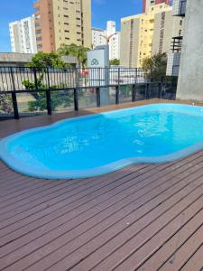 uma grande piscina azul num deque de madeira em Flat com vista para o Mar em Fortaleza