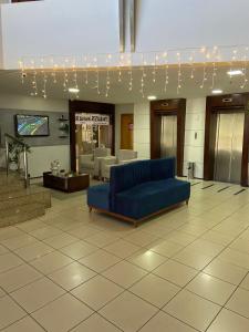 uma sala de estar com um sofá azul no átrio em Flat com vista para o Mar em Fortaleza mais 16 fotografias