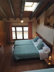 1 dormitorio con 2 camas y edredón verde en CASA RURAL LES ROQUETES, en Ráfales