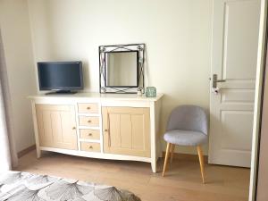 Zimmer mit einem TV, einem Spiegel und einem Stuhl in der Unterkunft Maison Sleep & Swim, 24H Le Mans Classic 2 B&B chambres d'hôtes in Fillé