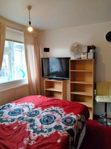 a bedroom with a bed and a flat screen tv at COSY ROOM 2 LONDOn in London