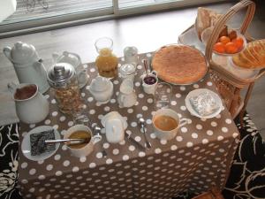 einen Tisch mit einem Tischtuch mit Polka-Punkten sowie Speisen und Getränken in der Unterkunft La Maison Salée in LʼAiguillon-sur-Mer