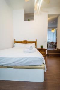 a bedroom with a white bed with a wooden headboard at Singular apartamento en Delicias by beBalmy in Madrid