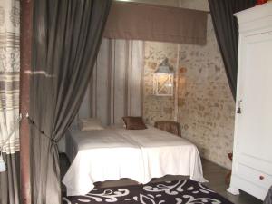 a bedroom with a white bed and a window at La Maison Salée in LʼAiguillon-sur-Mer