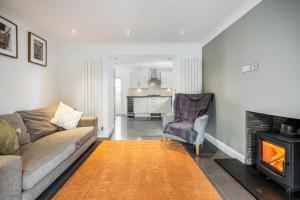 un salon avec un canapé et une cheminée dans l'établissement Daisy Cottage - Two bed country retreat, à Turriff