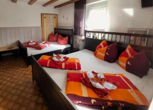 a room with three beds with colorful pillows on them at Ferienwohnung Hobbyhof Deggenhausertal in Deggenhausertal