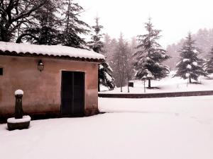 een klein gebouw met een deur in de sneeuw bij b&b Casa Alegría in Morano Calabro