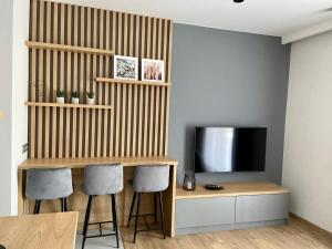 uma sala de estar com uma televisão e uma secretária com 2 cadeiras em Apartamenty WIERCHY em Klikuszowa