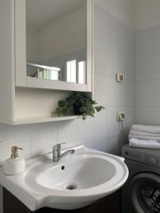 een badkamer met een wastafel en een wasmachine bij Sea You Soon! in Netanya
