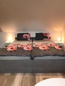 a bedroom with a large bed with pink flowers on it at Pension Alice in Apfelstädt