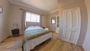 1 dormitorio con cama, ventana y puerta en Hotel La Casona del Desierto, en Huasco