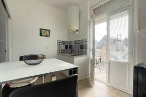 eine Küche mit einem Tisch und Stühlen sowie einem Fenster in der Unterkunft Appartement proche de la mer in Berck-sur-Mer