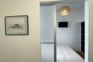 Schlafzimmer mit einer Glastür, die zu einem Bett führt in der Unterkunft Appartement proche de la mer in Berck-sur-Mer