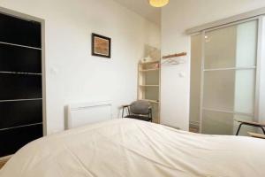 ein Schlafzimmer mit einem Bett, einem Stuhl und einem Fenster in der Unterkunft Appartement proche de la mer in Berck-sur-Mer